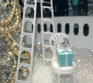 The iconic Tiffany blue gift box surrounded by jewels in the window of the Tiffany & Co. New York City store, Dec. 26, 2016 (Photo by Robert Fitzpatrick) Creative Commons license via Flickr