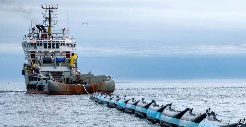 Ship tows The Ocean Cleanup's 2016 prototype plastic collector into the North Sea for testing. (Photo courtesy The Ocean Cleanup)