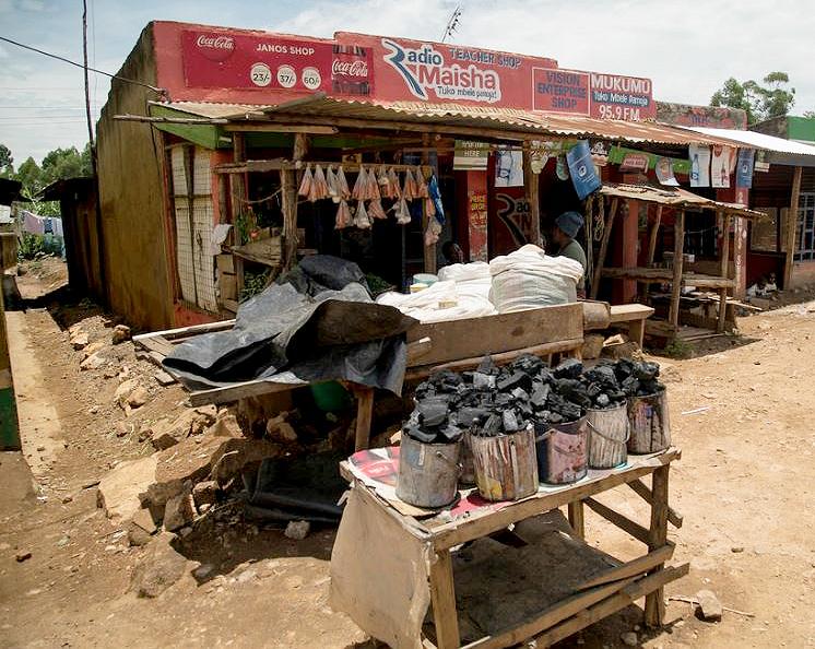 Businesses sell cans of charcoal for cooking at a market near Kisumu, Kenya, March 11, 2015. (Photo by Peter Kapuscinski / World Bank)