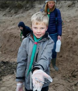 A member of the Gullane Beaver Scout Group finds cotton buds with plastic stems on Scotland's Gullane Beach, January 11, 2018 (Photo by Scottish Government) Creative Commons license via Flickr