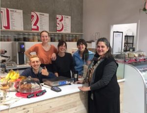 The first customer to shop at waste-free NADA Cafe, East Vancouver, Canada. Founder Brianne Miller, center, in black. October 22, 2018 (Photo courtesy NADA) Posted for media use.