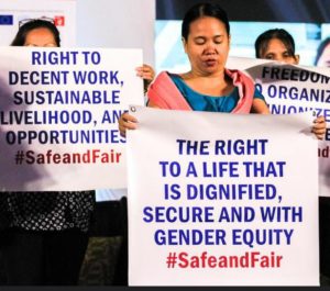 A group of women leads the Migrants/Women Workers Oath to protect, promote and defend their rights as women, as workers, and as migrants. They held placards to highlight the core rights and principles of their oath. The Philippines, April 16, 2019 (Photo by ILO Asia and the Pacific)