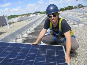 Installer with one of more than 3,600 solar panels being installed in Oakville, Ontario, Canada. July 23, 2015 (Photo by Rob Campbell) Creative Commons license via Flickr