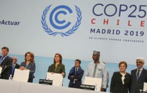 Dignitaries gather at the podium for the opening ceremony of the COP25 high-level segment. Front row second from left, Teresa Ribera, Minister for the Ecological Transition, Spain; Carolina Schmidt, COP25 President, Minister of the Environment, Chile; Tijjani Muhammad-Bande, President, UN General Assembly; Patricia Espinosa, Executive Director UN Climate Change, December 11, 2019 Madrid, Spain (Photo courtesy Earth Negotiations Bulletin)