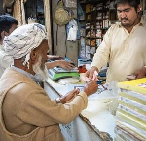 Azeem, 27, at his shop in Karachi, Pakistan. Afghan refugees like Azeem have recently been allowed to open bank accounts. 2019 (Photo by Roger Arnold courtesy UNHCR)