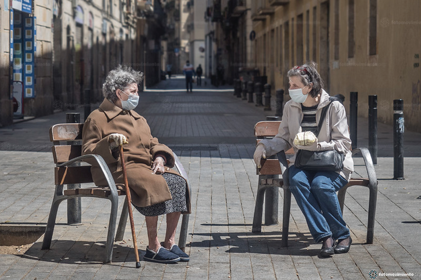 Mother and daughter maintain social distancing and wear protective masks as they share time in the spring sunshine, May 3, 2020, Barcelona, Spain (Photo by Fotomovimiento) Creative Commons license via Flickr 
