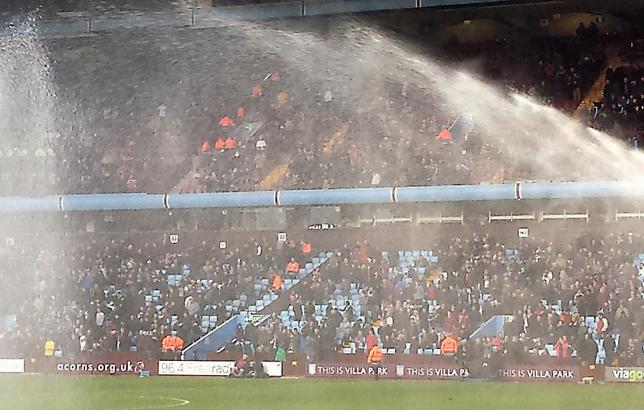 Villa Park is a football stadium in Aston, Birmingham, England. Ground staff water the football pitch to make the surface fast and slick. November 9, 2013 (Photo by John Garghan) Creative Commons license via Flickr 