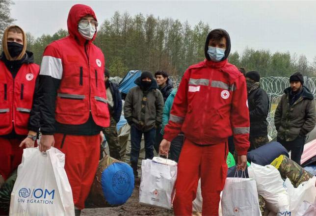 Volunteers from the Belarus Red Cross deliver humanitarian aid to refugees and migrants blocked by barbed wire from entering the European Union at the Polish border. UN agencies are calling for an immediate de-escalation, following weeks of rising tension. November 9, 2021 (Photo courtesy UN International Organization for Migration) Posted for media use